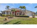 Single Gathering home with lush green lawn, mature palms, and a neutral paint palette at 9428 Bandera Ln, Port Charlotte, FL 33981