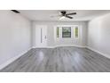 Bright living room featuring elegant wood-look floors, a front door and a large window for natural light at 11176 3Rd Ave, Punta Gorda, FL 33955