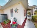 Charming exterior featuring attractive landscaping, a decorative star, and a cozy screened entrance at 1286 Green Oak Trl, Port Charlotte, FL 33948