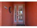 Close up of a sidelight front door featuring a digital lock and a welcome mat at 1344 Mediterranean Dr # 121, Punta Gorda, FL 33950