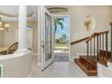 Bright foyer features decorative glass front door, wooden staircase, and tile flooring that leads into the home at 1453 Wren Ct, Punta Gorda, FL 33950