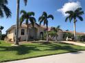 Attractive single Gathering home with lush lawn, palm trees, neutral paint and terracotta tile roof under blue skies at 1453 Wren Ct, Punta Gorda, FL 33950