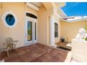 Charming front porch with tile flooring, white pillars, round window, and seating for enjoying the outdoors at 1453 Wren Ct, Punta Gorda, FL 33950