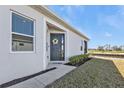 Inviting front entrance with a lovely wreath, manicured landscaping, and serene golf course backdrop at 1875 Nottingham Trl, Punta Gorda, FL 33980