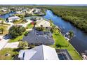 Aerial view of waterfront homes with boat docks and waterway access. A lovely view of a sunny neighborhood at 19179 Aviation Ct, Port Charlotte, FL 33948