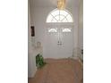 Bright foyer features tile flooring, double doors, transom window, and a sparkling chandelier at 223 Valdiva St, Punta Gorda, FL 33983