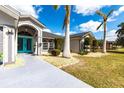 Inviting front entrance with a bright blue double door, decorative landscaping, and a modern design at 23144 Donalda Ave, Port Charlotte, FL 33954