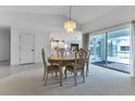 Dining room featuring carpeted floors, chandelier, and views of the lanai at 23411 Superior Ave, Port Charlotte, FL 33954