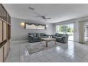 Cozy living room featuring tile flooring, ceiling fan, and comfortable seating at 23411 Superior Ave, Port Charlotte, FL 33954