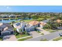 Attractive front exterior featuring a well-maintained lawn, two-car garage, and a view of the community pond and golf course at 25197 Keygrass Ct, Punta Gorda, FL 33955