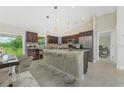 Spacious kitchen with dark wood cabinets, granite countertops, and a large center island with barstool seating at 2851 Verde Ter, North Port, FL 34286