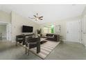 Bright living room features vaulted ceiling, gray tile flooring, neutral walls, and modern furniture and decor at 2851 Verde Ter, North Port, FL 34286