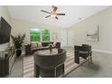 Comfortable living area showcases tile floors, a ceiling fan, and large windows for natural light at 2851 Verde Ter, North Port, FL 34286