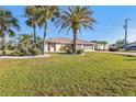 Beautiful single-story home with lush green lawn and tropical landscaping, showcasing curb appeal at 295 Porto Alegre St, Punta Gorda, FL 33983