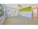 Sunlit living room with tile floors, ceiling fan and natural light with view to another room through a large entrance at 3615 Sleepy Hollow Ln, Punta Gorda, FL 33950