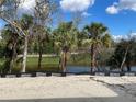 Scenic lot view features lush landscaping, mature trees, and serene water feature at 4463 Kennett St, North Port, FL 34288