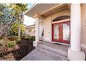Charming front entrance featuring a double door with columns and landscaped garden at 1217 Bobwhite Court, Punta Gorda, FL 33950