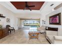 Bright living room with tile floors, fan, and sliding glass doors leading to a screened-in patio and pool at 1217 Bobwhite Court, Punta Gorda, FL 33950