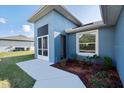 Back exterior view of home with landscaping, a window and side door at 2405 Vancouver Ln, North Port, FL 34286