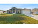Charming single-story home featuring a manicured front yard and two-car garage at 2405 Vancouver Ln, North Port, FL 34286