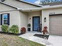 Inviting front porch with blue front door, accent plants, and a classic rocking chair at 2822 Logsdon St, North Port, FL 34287