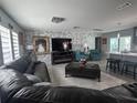 Bright living room featuring a modern brick accent wall and gray tile floors at 3289 Pellam Blvd, Port Charlotte, FL 33948