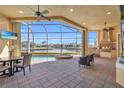Covered patio with outdoor kitchen, dining, seating, and a pool overlooking waterfront at 3321 Tripoli Blvd, Punta Gorda, FL 33950