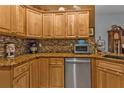 Inviting kitchen featuring granite countertops, tile backsplash, stainless appliances, and ample cabinet space at 4504 Vaquero St, North Port, FL 34286