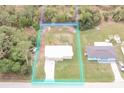 Aerial view of a property showcasing its lot size and the home's location among lush trees and nearby residences at 11369 1St Ave, Punta Gorda, FL 33955