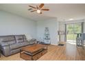 Comfortable living room with wood floors, a ceiling fan, and a view into the bright kitchen at 11369 1St Ave, Punta Gorda, FL 33955