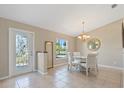 Bright dining room with tile floors, a decorative window-paneled door, chandelier, and a table with four chairs at 1391 Abalom St, Punta Gorda, FL 33980