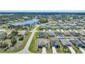 Overview of a residential community with homes, streets, and a scenic pond surrounded by lush trees at 149 Hercules Dr, Rotonda West, FL 33947