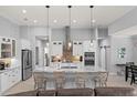 A modern kitchen boasts a large marble island, stainless steel appliances, and stylish pendant lighting at 158 Mariner Ln, Rotonda West, FL 33947