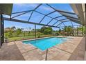 Relaxing screened-in pool area with brick pavers, and lush landscaping perfect for outdoor entertaining at 158 Mariner Ln, Rotonda West, FL 33947