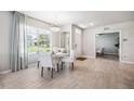 Dining area featuring wood-look tile floors, a modern chandelier, and a large window at 2138 Royal Tern Cir, Punta Gorda, FL 33983