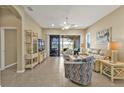 Bright living room featuring neutral tones, tile floors, and sliding glass doors leading to the outdoor living space at 24036 Buckingham Way, Port Charlotte, FL 33980