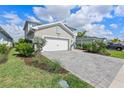 Attractive home with a brick driveway, lush green lawn, and appealing curb appeal at 43554 Treadway Dr, Punta Gorda, FL 33982