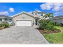 Beautiful two-story home with gray siding, a large brick driveway, and well-maintained landscaping at 43554 Treadway Dr, Punta Gorda, FL 33982