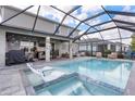 Inviting screened-in pool with a connected spa, outdoor bar area, and comfortable seating at 43554 Treadway Dr, Punta Gorda, FL 33982