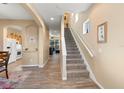 Spacious hallway with tile floors, staircase, and views into the kitchen and living room at 1071 Jonah Dr, North Port, FL 34289