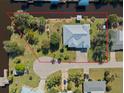 Aerial view of single-Gathering home on a waterfront lot with mature trees and landscaping at 2012 River Basin Ter, Punta Gorda, FL 33982