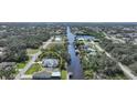 Aerial view of property on canal, with pool, boat dock and lush landscaping at 3487 Cabaret St, Port Charlotte, FL 33948