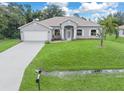 Well-maintained home featuring a lush green lawn, a pristine driveway, and a two-car garage at 5366 Dunsmuir Rd, North Port, FL 34288