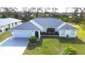 Charming single-story home featuring a well-manicured lawn and mature landscaping with a two car garage at 6170 David Blvd, Port Charlotte, FL 33981