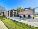 Exterior elevation of house with beige exterior, screened in porch, and decorative stone landscaping at 8858 Tuscany Isles Dr, Punta Gorda, FL 33950