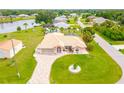 Aerial view of a pink house with a circular driveway near a lake at 256 Coblentz St, Port Charlotte, FL 33954