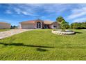 Ranch-style home with a landscaped yard and driveway under a sunny sky at 256 Coblentz St, Port Charlotte, FL 33954