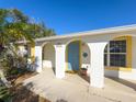 Charming home featuring white exterior with colorful blue door and yellow trim details at 13468 Romford Ave, Port Charlotte, FL 33981