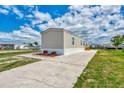 Side view of tan mobile home, landscaping, and boat at 1391 Flamingo Dr, Englewood, FL 34224