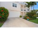 Exterior view of a two-story townhome with a garage and lush landscaping at 10309 Coral Landings Ct # 101, Placida, FL 33946